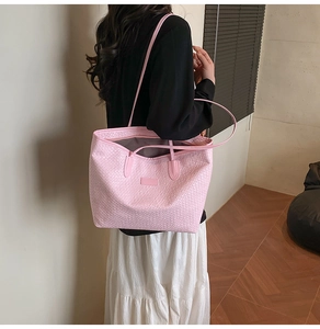 Close-up of pink woven texture on large tote bag with long leather shoulder straps