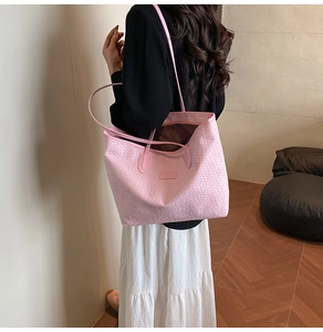 Detail of pink woven texture on large tote bag with slim shoulder straps and sleek finish