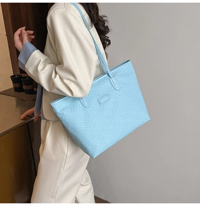 Detailed close-up of woven light blue faux leather texture on a stylish tote bag