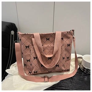 Dettaglio della borsa tote in velluto rosa con motivi a fiocco nero e design trapuntato