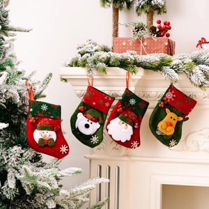 Set of 4 Christmas stockings with snowman and Santa hanging on a festive fireplace mantle