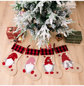 Detail of four Christmas stockings with buffalo plaid cuffs and 3D gnome appliques