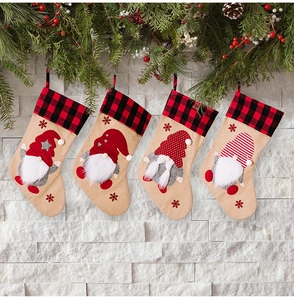 Detail of burlap Christmas stockings with gnome embroidery and red buffalo plaid cuffs