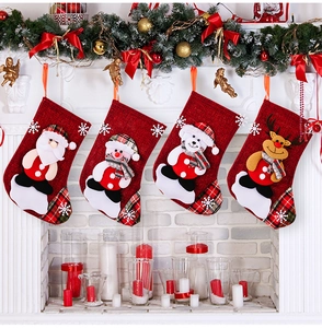 Detailed view of four festive linen Christmas stockings hanging on a white mantel fireplace