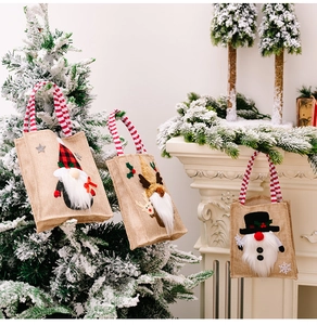 Close-up of burlap Christmas gift bags with 3D gnome applique and striped handles