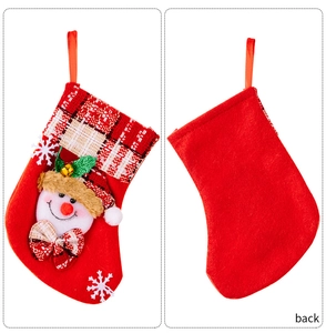 Détail d'une chaussette de Noël rouge avec appliqué bonhomme de neige, revers à carreaux