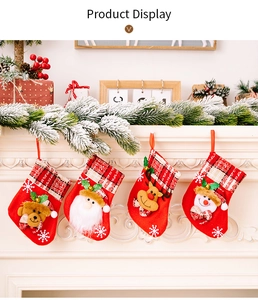 Détail de quatre mini chaussettes de Noël avec bordure à carreaux sur une cheminée