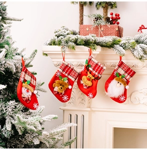 Détail de quatre chaussettes de Noël avec poupées de dessin animé sur une cheminée blanche