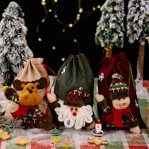 Detailed view of three burlap Christmas gift bags with 3D Santa, reindeer and snowman dolls