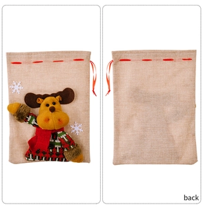 Detail of Christmas burlap gift bag with 3D reindeer doll and red drawstring closure