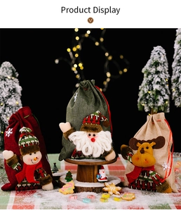 Three festive burlap Christmas gift bags featuring Santa, snowman, and reindeer plush dolls