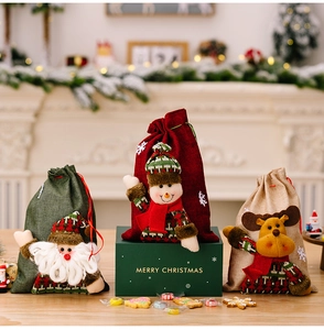 Detail of Christmas burlap gift bags featuring 3D plush Santa, Snowman and Reindeer characters