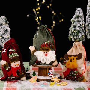 Three Christmas burlap drawstring gift bags with Santa, Elk, and Snowman plush dolls