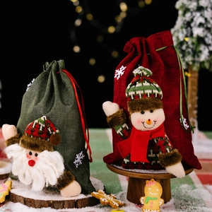 Christmas burlap gift bags with 3D Santa and Snowman plush dolls on snowy wood tray