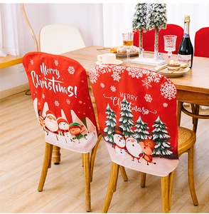 Detail of red Christmas chair covers with festive Santa and reindeer patterns for dining decor