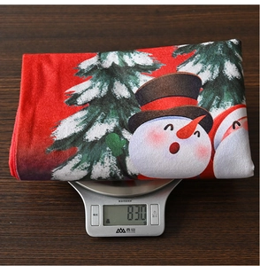 Detailed shot showing the 83.0g weight of the red Christmas chair cover on a digital scale