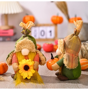Detail of autumn gnome plush with sunflower and pumpkin in warm festive decor