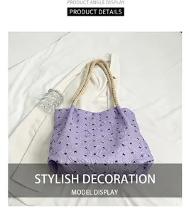 Close-up of purple tote bag featuring black bow patterns and beige rope handles