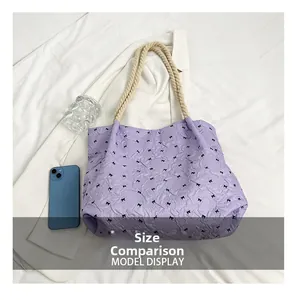 Detailed top view of purple bucket bag with black bow prints and rope handles showing size