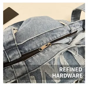Macro shot of washed blue denim bag featuring vintage bronze zipper and frayed edges