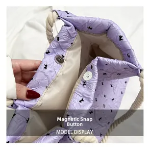 Detail view of purple ruched bag with letter K print and magnetic buckle closure