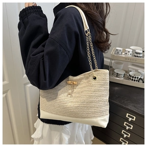 Detail of straw shoulder bag with leather bottom, gold chain and deer charm