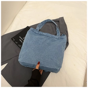 Detail of blue denim tote bag texture and handles on a minimalist lifestyle background