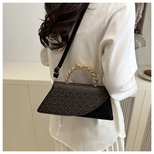 Detail of vintage tote bag featuring gold woven handle and monogram pattern on leather