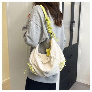 Détail du sac fourre-tout en nylon blanc cassé avec bandoulière plissée vert fluo et cordon