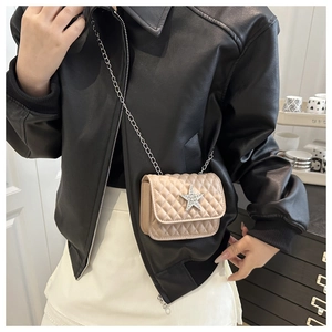 Détail du mini sac beige matelassé avec une étoile en strass et une bandoulière chaîne
