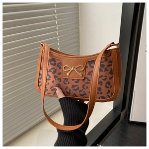 Detail view of leopard print baguette bag with elegant golden metallic bow buckle