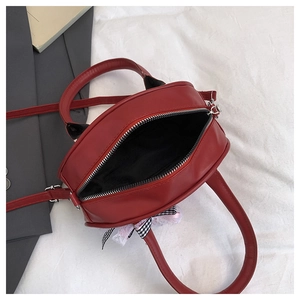 Detalle del bolso rojo con lazo de cuadros blanco y negro, encaje y vista del forro interior