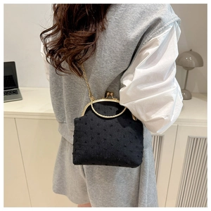 Détail du sac à main vintage à pois noirs avec poignée anneau dorée et chaînette