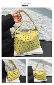 Détail du sac à bandoulière en cuir grainé jaune avec décorations de clous argentés