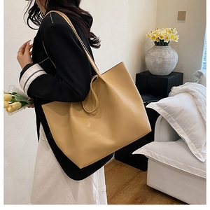 Minimalist beige tote bag shown on shoulder of a model in professional work attire