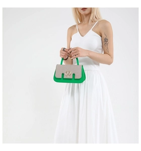 Detail of green leather handbag with woven beige flap and golden ring buckle closure