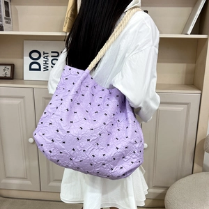 Lavender quilted bucket tote bag with black bows and cream rope handle on shoulder