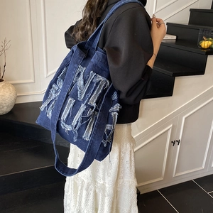 Deep blue denim tote bag with frayed letter patchwork in a street style shoulder design