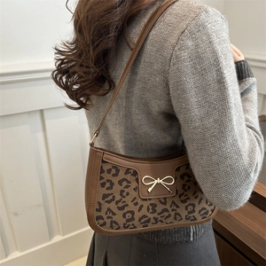 Brown leopard print shoulder bag with gold metal bow charm and leather panel design