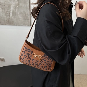 Chic leopard print underarm bag for women featuring a gold metal bow and leather texture