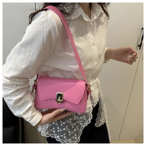 Detail of pink faux leather crossbody bag with a gold metal twist lock and smooth texture