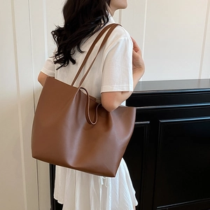 Large brown matte leather tote bag shown on model from a side view for daily commuting