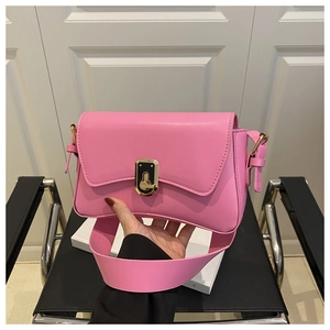 Détail d'un sac sous les bras rose vif avec une boucle noir-or vintage et bandoulière large