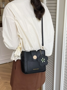 Sac seau chic en cuir noir avec boucle en bois et breloque florale en bandoulière