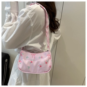 Dettaglio della borsa a spalla rosa con stampa floreale di rose e fiocchi eleganti