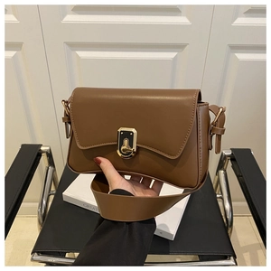 Détail du sac bandoulière en cuir marron avec fermoir rotatif carré doré vintage