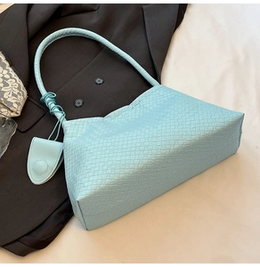Gros plan sur la texture tressée bleu clair avec nœud et petit porte-monnaie assorti