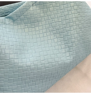 Gros plan sur la texture en cuir tissé bleu clair d'un sac à bandoulière pour femme