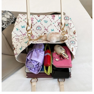 Interior view of large white quilted tote bag showing daily essentials and cute cartoon prints