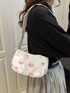 Borsa a spalla bianca con rose e fiocchi rosa indossata per uno stile quotidiano
